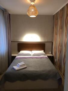 1 dormitorio con 1 cama con 2 toallas en Grad Hotel, en Cherepovets