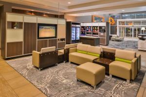 a lobby with couches and a flat screen tv at Holiday Inn Kansas City Airport, an IHG Hotel in Kansas City
