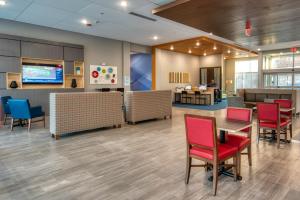 um lobby de um hospital com cadeiras vermelhas e uma mesa em Holiday Inn Express & Suites - Omaha Downtown - Airport, an IHG Hotel em Omaha