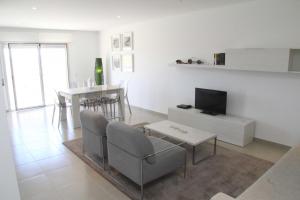 uma sala de estar com uma televisão e uma mesa e cadeiras em Carmona - Holiday Apartments - By SCH em São Martinho do Porto