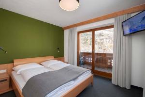 sypialnia z łóżkiem i dużym oknem w obiekcie Gurglhof Apartmenthaus w mieście Obergurgl
