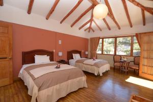 a bedroom with two beds in a room at Hotel Pisonay Pueblo in Urubamba