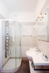 a white bathroom with a shower and a sink at Residence Rizzante in Caorle