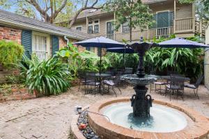 a fountain with two umbrellas in a courtyard at Andrew Jackson Hotel French Quarter in New Orleans