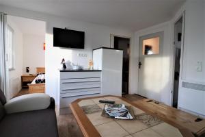 ein Wohnzimmer mit einem Kühlschrank und einem Tisch in der Unterkunft Monteurwohnung - Berghütte - KEK3 - keine Touristen in Bad Blankenburg