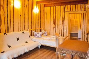 a bedroom with two beds and a bench in a room at Gostynniy Dvir Raytshtoky in Vorokhta