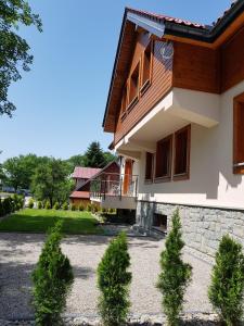 ein Haus mit Bäumen davor in der Unterkunft Pod Modrzewiami in Krynica-Zdrój