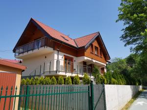 una casa con una valla delante de ella en Pod Modrzewiami en Krynica Zdrój