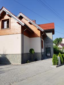 una casa con techo rojo y entrada en Pod Modrzewiami, en Krynica-Zdrój