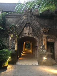an entrance to a stone building with a pathway at Ibah in Ubud