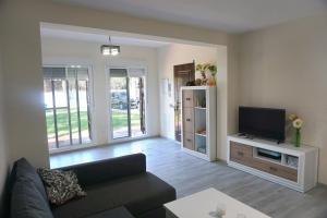 salon z kanapą i telewizorem z płaskim ekranem w obiekcie Relax y playa en la Barrosa w mieście Chiclana de la Frontera