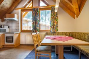 kuchnia i jadalnia ze stołem i oknem w obiekcie Apart Bergblick w mieście Ischgl