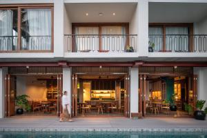 a person walking in front of a building at Hotel Gahn - SHA Plus in Khao Lak