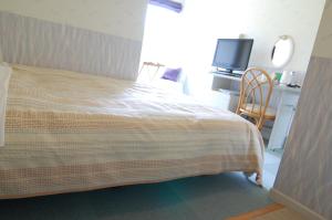 sypialnia z łóżkiem, biurkiem i telewizorem w obiekcie Ito - Hotel / Vacation STAY 64402 w mieście Ito