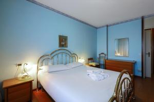 a bedroom with a large white bed with blue walls at PrimoPiano - San Dionigi in Milan