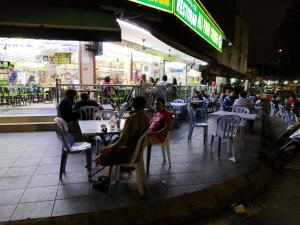 a group of people sitting at tables outside a restaurant at Coffee & Tea Homestay 2 in Kuala Lumpur