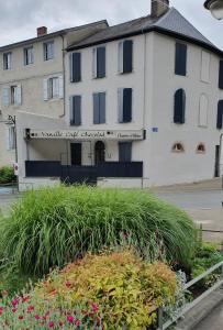 un bâtiment blanc avec un panneau à l'avant dans l'établissement VANILLE CAFE CHOCOLAT, à Bagnères-de-Bigorre