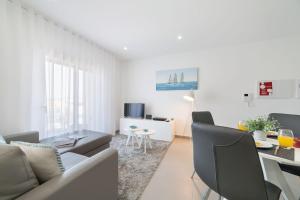 Palhanas - Holiday Homes - By SCH في Salir de Porto: غرفة معيشة بيضاء مع أريكة وطاولة