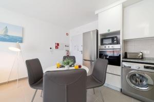 uma cozinha com uma mesa e cadeiras numa cozinha em Palhanas - Holiday Homes - By SCH em Salir do Porto