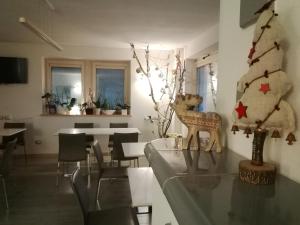 ein Esszimmer mit einem Weihnachtsbaum und einem Tisch in der Unterkunft Affittacamere Rubino Guest House in Ponte nellʼAlpi