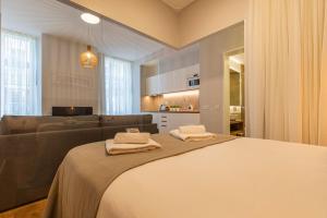 ein Schlafzimmer mit einem großen Bett und einem Sofa in der Unterkunft Upscale & Trendy flat in the Center in Lissabon