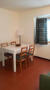 jadalnia z białym stołem i krzesłami w obiekcie Appartamento San Bartolomeo w mieście Passo del Tonale