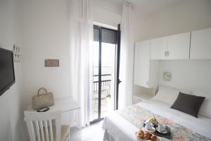 a bedroom with a bed and a desk with shoes on it at Hotel Morri in Bellaria-Igea Marina