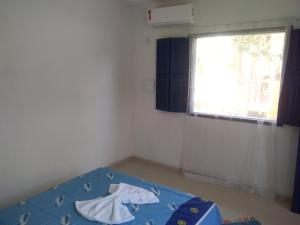 um pequeno quarto com uma cama e uma janela em Hospedaria Cosanostra em Itaúnas