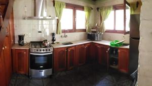 Una cocina con gabinetes de madera y un horno de estufa. en La Casa de Lili, en La Pedrera