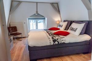 a bedroom with a large bed with red pillows at Top Of The City in Amsterdam
