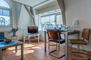 uma sala de estar com uma mesa e cadeiras e uma televisão em Top Of The City em Amsterdã