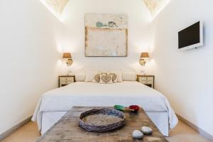 a bedroom with a bed and a wooden table at B&b Casa Maredentro in Monopoli