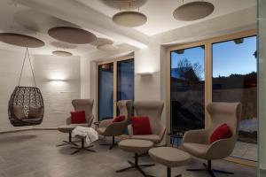 una sala de espera con sillas y una lámpara de araña en Apart-Hotel Dreisonnenhof, en Fiss