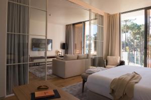 a hotel room with a bed and a living room at Aroeira Lisbon Hotel - Sea & Golf in Aroeira