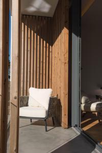 a chair on a balcony with a wooden wall at Aroeira Lisbon Hotel - Sea & Golf in Aroeira