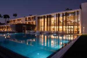 a large building with a swimming pool at night at Aroeira Lisbon Hotel - Sea & Golf in Aroeira