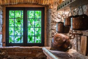 Faedis的住宿－TORRE DEL GRIFONE nel medioevo di Cividale del Friuli，厨房设有窗户和铜盆