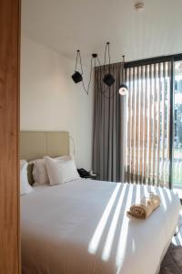a bedroom with a white bed and a window at Aroeira Lisbon Hotel - Sea & Golf in Aroeira