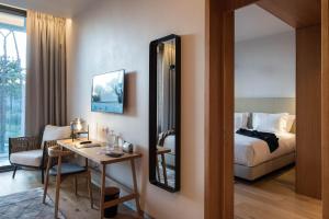 a hotel room with a bed and a desk and a mirror at Aroeira Lisbon Hotel - Sea & Golf in Aroeira