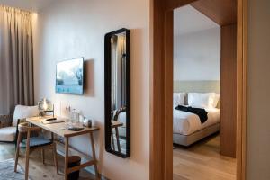 a room with a bed and a table and a mirror at Aroeira Lisbon Hotel - Sea & Golf in Aroeira