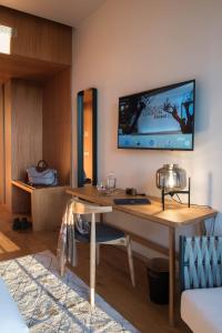 a room with a desk with a television on the wall at Aroeira Lisbon Hotel - Sea & Golf in Aroeira