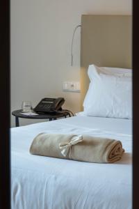 a purse sitting on top of a bed with a phone at Aroeira Lisbon Hotel - Sea & Golf in Aroeira