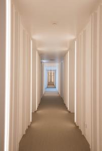 an empty corridor with white walls and a long aisle at Aroeira Lisbon Hotel - Sea & Golf in Aroeira