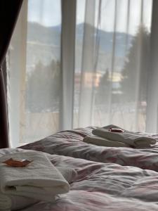 a bed with towels on it next to a window at Apartment Bischofshofen in Bischofshofen