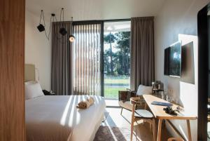 a hotel room with a bed and a table and a desk at Aroeira Lisbon Hotel - Sea & Golf in Aroeira