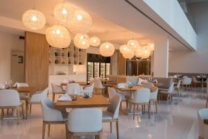 a restaurant with tables and chairs and chandeliers at Aroeira Lisbon Hotel - Sea & Golf in Aroeira