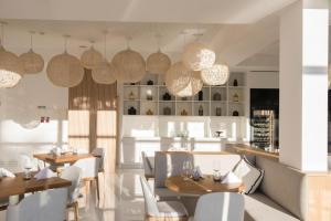 a dining room with tables and chairs and pendant lights at Aroeira Lisbon Hotel - Sea & Golf in Aroeira