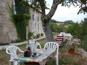 - une table et des chaises dans une cour à côté d'un bâtiment dans l'établissement Casa do Comediante, à Cerdeira