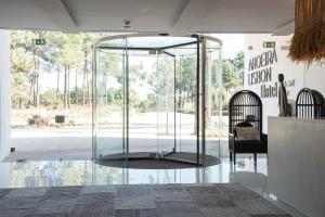a glass room with a table and a chair at Aroeira Lisbon Hotel - Sea & Golf in Aroeira
