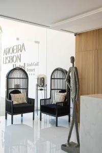 a statue of a man walking in front of two beds at Aroeira Lisbon Hotel - Sea & Golf in Aroeira
